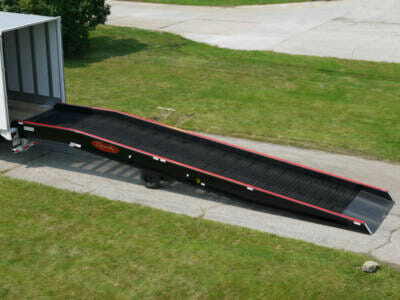 Portable loading dock ramp connected to semi trailer